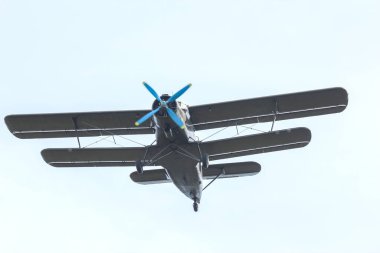 Mavi pervaneli klasik bir çift kanatlı uçak güneşli bir günde gökyüzünde süzülür..