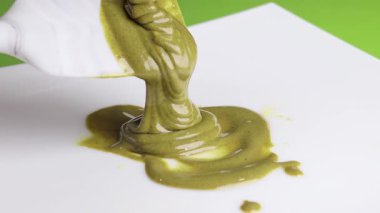 Pistachio kreması, beyaz arka planda spatulaya damlatılmış spatula. Yemek ve krema. Yemek ve doğal ürün. - Evet. Yüksek kalite 4k görüntü