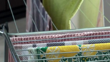 Kadın ıslak havluları asıyor, çarşafları kurutma askısına asıyor. Temizlik ve oda temizliği. Evle ve siparişlerle ilgileniyordum. Yaşam tarzı. - Evet. Yüksek kalite 4k görüntü