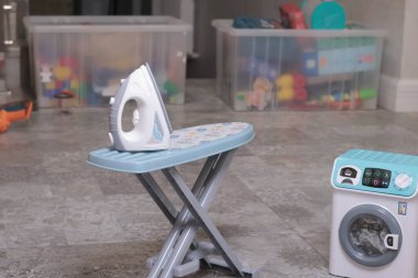 Oyuncak ev aletleri, ütü masası, yerde çamaşır makinesi. Temizlik, ev işleri, bebek ve eğitim oyunları. - Evet. Yüksek kalite fotoğraf