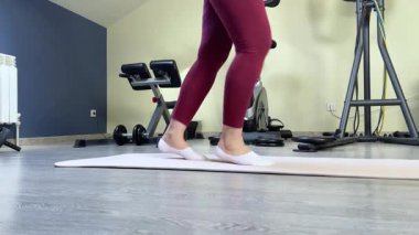 50 'li yaşlarda bir kadın evinde ip atlıyor. Spor malzemeleri ve spor için oda. Sağlık ve egzersiz. - Evet. Yüksek kalite 4k görüntü