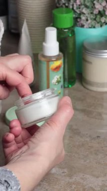 Modern banyoda cam kavanoz kremi açık sabahlık giymiş bir kadın. Güzellik ve bakım, spa rutinleri. Yüz besleyici krem. - Evet. Yüksek kalite 4k görüntü