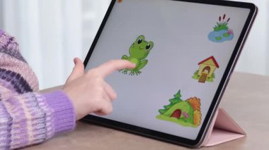 Kız tablette eğitim oyunuyla oynuyor. Okul öncesi gelişim ve teknoloji. Hayvanlar ve ev. - Evet. Yüksek kalite 4k görüntü