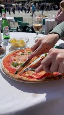 Portofino, İtalya - 07 Nisan 2025. İtalya 'da Aperitivo caddesinde. Becks birası. Yiyecek ve içecek. Adam Margherita pizzasını bıçakla kesti. - Evet. Yüksek kalite 4k görüntü