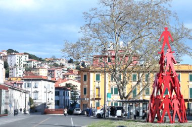 La Spezia, İtalya 'daki tren istasyonunun meydanı, 2025. Geleneksel evler, binalar ve kırmızı koni şekilli modern heykeller. Yüksek kalite fotoğraf