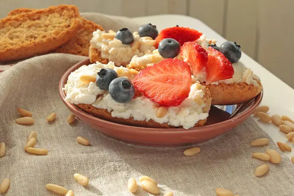 Rostini, ricotta, böğürtlen, çam fıstığı. Kahvaltıda peynirli kızarmış ekmek dilimleri. Sağlıklı bir yemek ve atıştırmalık. Yüksek kalite fotoğraf