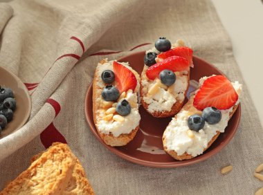 Rostini, ricotta, böğürtlen, çam fıstığı. Kahvaltıda peynirli kızarmış ekmek dilimleri. Sağlıklı bir yemek ve atıştırmalık. Yüksek kalite fotoğraf