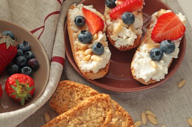 Rostini, ricotta, böğürtlen, çam fıstığı. Kahvaltıda peynirli kızarmış ekmek dilimleri. Sağlıklı bir yemek ve atıştırmalık. Yüksek kalite fotoğraf