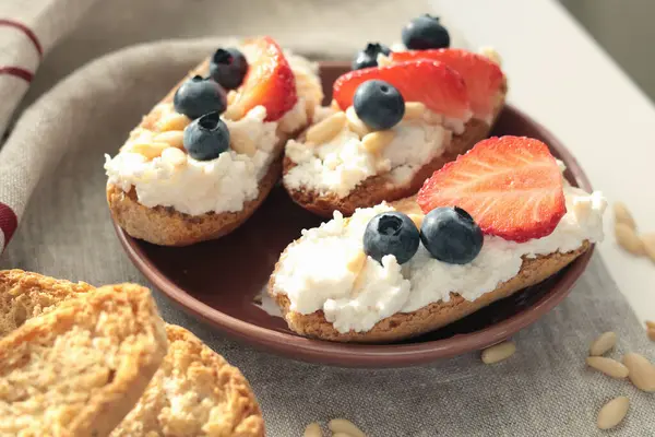 Rostini, ricotta, böğürtlen, çam fıstığı. Kahvaltıda peynirli kızarmış ekmek dilimleri. Sağlıklı bir yemek ve atıştırmalık. Yüksek kalite fotoğraf