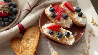 Rostini, ricotta, böğürtlen, çam fıstığı. Kahvaltıda peynirli kızarmış ekmek dilimleri. Sağlıklı yemek ve atıştırmalık. Yüksek kalite 4k görüntü