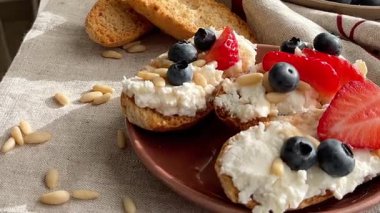 Rostini, ricotta, böğürtlen, çam fıstığı. Kahvaltıda peynirli kızarmış ekmek dilimleri. Sağlıklı yemek ve atıştırmalık. Yüksek kalite 4k görüntü
