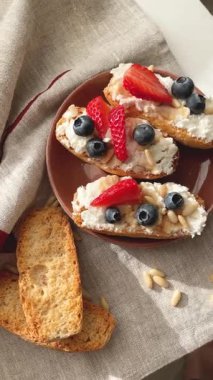 Rostini, ricotta, böğürtlen, çam fıstığı. Kahvaltıda peynirli kızarmış ekmek dilimleri. Sağlıklı yemek ve atıştırmalık. Yüksek kalite 4k görüntü
