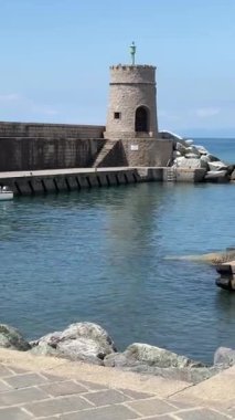 Liguria 'nın Recco kasabasındaki taş gibi eski deniz feneri. Doğa, turizm ve eğlence, İtalya. Yüksek kalite 4k görüntü
