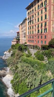 Liguria ve deniz kenarındaki eski geleneksel kaya binaları. İtalya 'nın limanındaki Camogli kasabası ve deniz feneri. Dağdan panoramik manzara. Turizm ve eğlence sektörü. Yüksek kalite 4k görüntü