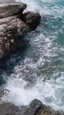 Gök mavisi deniz dalgaları kayalara çarpıyor. Güneşli bir hava. Liguria 'da tatil. Doğa ve meditasyon. - Evet. Yüksek kalite 4k görüntü