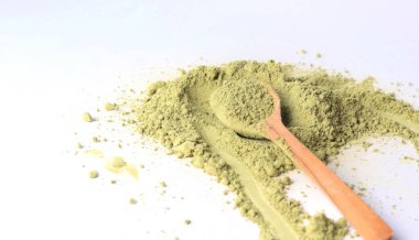 Japon pudralı kibrit yeşil çay, tahta kaşıkta. Antioksidan, sağlıklı, organik ürün. İçecekler ve beslenme. Beyaz arkaplandaki izole görüntü. Yüksek kalite fotoğraf