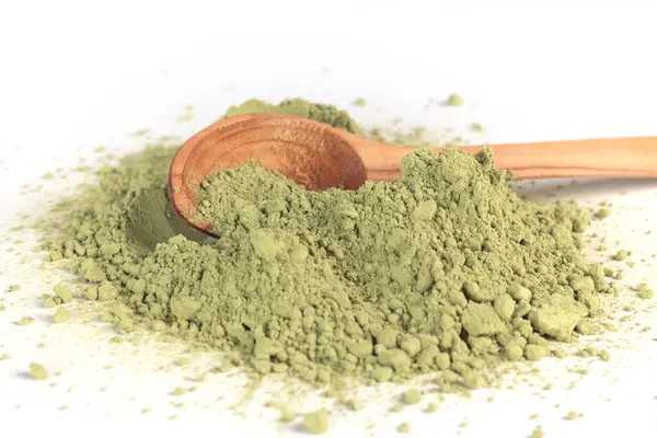 Japon pudralı kibrit yeşil çay, tahta kaşıkta. Antioksidan, sağlıklı, organik ürün. İçecekler ve beslenme. Beyaz arkaplandaki izole görüntü. Yüksek kalite fotoğraf
