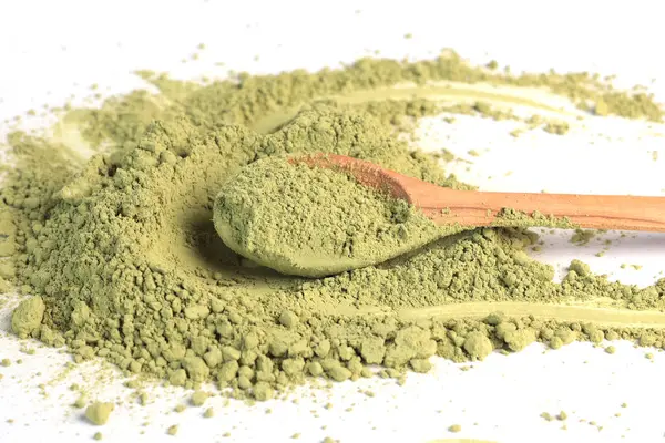 Japon pudralı kibrit yeşil çay, tahta kaşıkta. Antioksidan, sağlıklı, organik ürün. İçecekler ve beslenme. Beyaz arkaplandaki izole görüntü. Yüksek kalite fotoğraf