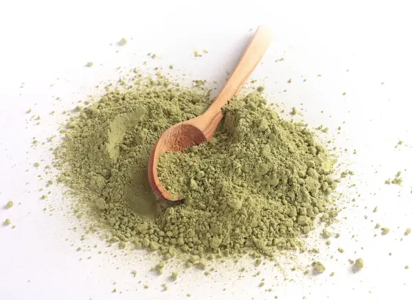 Japon pudralı kibrit yeşil çay, tahta kaşıkta. Antioksidan, sağlıklı, organik ürün. İçecekler ve beslenme. Beyaz arkaplandaki izole görüntü. Yüksek kalite fotoğraf