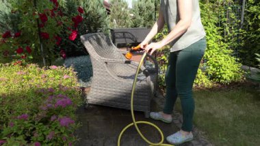 İsimsiz temizlik, yazın hasır mobilya hortumu. Arka bahçe binaları. Temizlik ve düzen. Yüksek kalite 4k görüntü