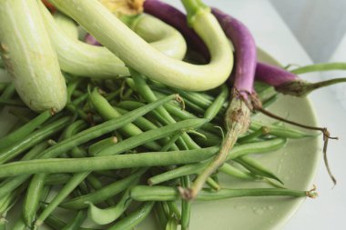Tabakta alışılmadık şekilli sebzeler. Kabak ve patlıcan, kuşkonmaz fasulyesi. Mevsimlik gıda ve çiftlik organik ürünleri. Yüksek kalite fotoğraf