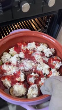 Kadın peynirin altına çiğ patlıcan koymuş. Küçük patlıcanlar kasede. Sebzeler ve sağlıklı yiyecekler. Bahçeden organik ürünler. Yüksek kalite 4k görüntü