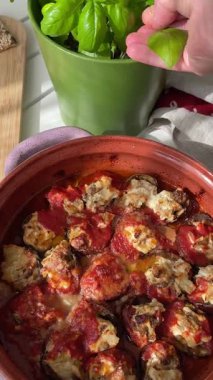 Kadın peynirin altına fesleğen yaprağı koymuş. Küçük patlıcanlar kasede. Sebzeler ve sağlıklı yiyecekler. Bahçeden organik ürünler. Yüksek kalite 4k görüntü