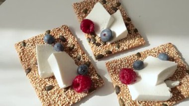 Tohum, peynir, ricotta ve böğürtlenli gevrek tahıl ekmeği. Kahvaltı ve sağlıklı beslenme. Yüksek kalite 4k görüntü