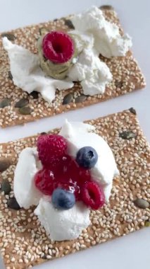 Tohum, peynir, ricotta ve böğürtlen ve marmelatlı gevrek tahıl ekmeği. Kahvaltı ve sağlıklı beslenme. Yüksek kalite 4k görüntü