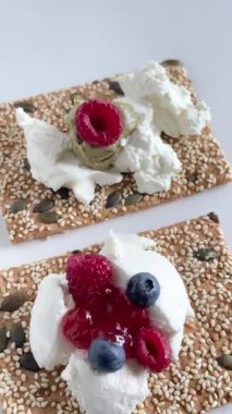 Tohum, peynir, ricotta ve böğürtlen ve marmelatlı gevrek tahıl ekmeği. Kahvaltı ve sağlıklı beslenme. Yüksek kalite 4k görüntü