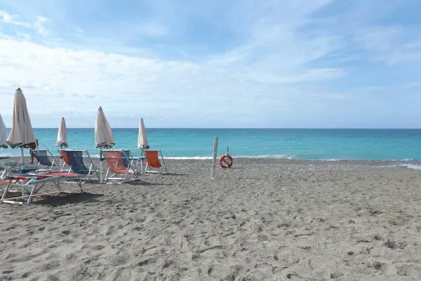 Deniz kıyısındaki Lacoste markasının plaj şemsiyeleri ve güneş şezlongları. Yaz, Liguria, İtalya 'da tatil. Metin için arka plan. Yüksek kalite fotoğraf