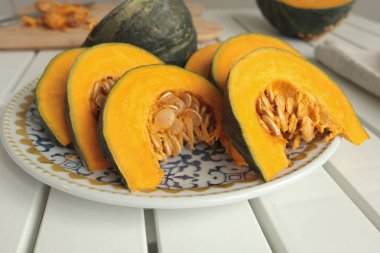 Parçalar, porselen tabakta mavi desenli balkabağı dilimleri. Çiftlik ürünleri ve sağlıklı beslenme. Mutfak ve ev yemekleri. Yüksek kalite fotoğraf