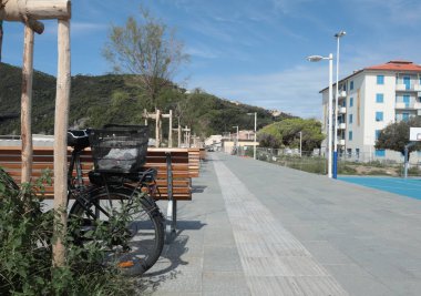 Yeni gezinti alanı, deniz kenarındaki genç ağaçlarla dolgu, park, tatil köyündeki banklar. Doğa ve eğlence. Güneşli bir gün ve açık bir gökyüzü. Ekolojik olarak temiz doğa. Yüksek kalite fotoğraf