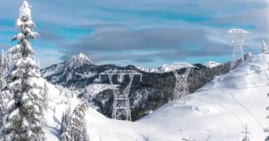 Mountain Snow Timelapse 'daki elektrik güç aktarım kuleleri. Kışın Orman Vadisi boyunca uzanan Kablolu Uzun Güç Ağı Yapıları