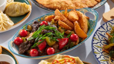 Patatesli et, otlar ve dolmalık biberli domatesler diğer benzer Asya yemekleri arasında beyaz arka planda