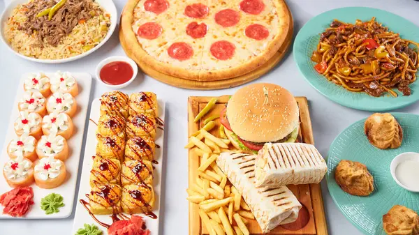 Farklı yemekler. Pizza, burger, manti, lagman, donör, suşi. Işık arkaplanının üst görüntüsü. Yüksek kalite fotoğraf