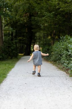 Parkta yolda koşan küçük çocuk. Yaz zamanı..