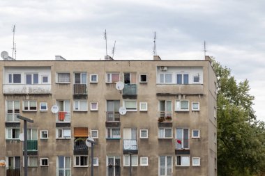 Balkonları ve pencereleri olan yeni, modern bir apartmanın ön cephesi.