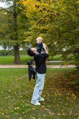 Genç anne ve küçük oğlu sonbahar parkında eğleniyorlar..