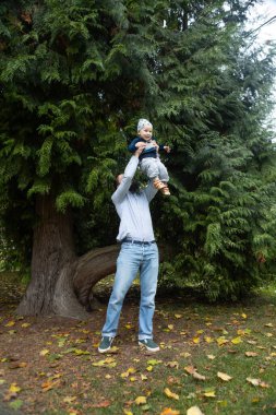 Genç baba ve oğlu sonbahar parkında. Mutlu aile kavramı..