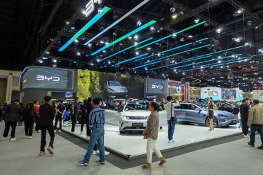 Nonthaburi, Tayland - 30 Kasım 2024: Bangkok Motor Show 'da çeşitli insanlar tarafından çevrelenmiş çeşitli elektrikli ve gelişmiş araçlarla dolu BYD kabini büyük kapalı sergi alanı.