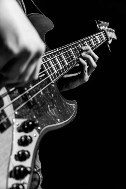 Siyah beyaz bas gitaristin yakın plan fotoğrafı.