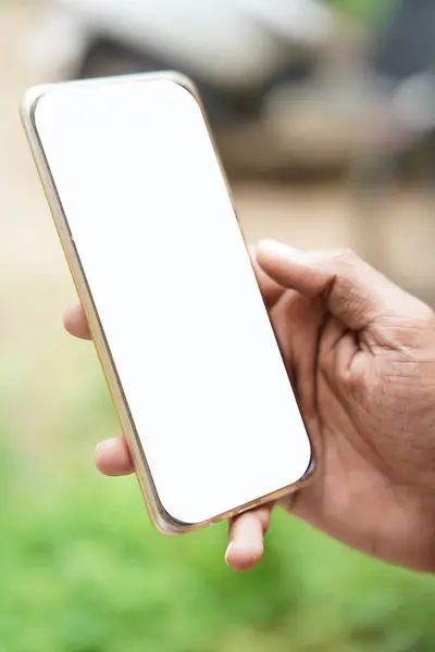 Beyaz, boş bir cep telefonu ekranının bir maketi bir ofis ortamında masasında mesaj atan bir kadının elinden tutuluyor. Arkaplan