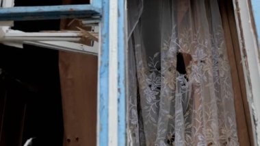 Binanın bombalanması, camların kırılması, Ukrayna 'nın yıkımı, Rusya' nın sivilleri vurması. Kırık cam kırıkları. Yıkılmış bina, kırılmış pencere ahşabı.