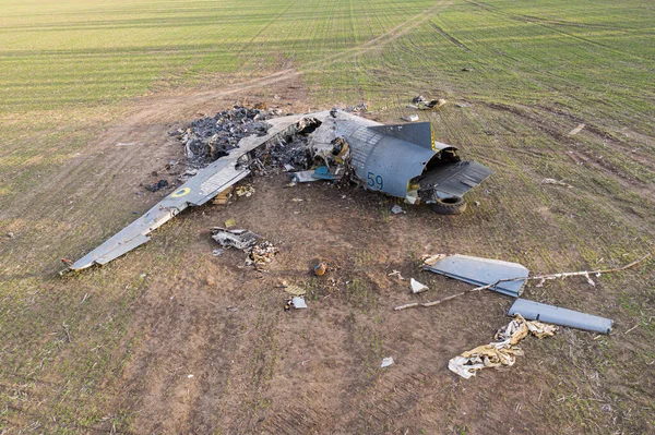 Bu resimde, bir AN-26 uçağının Ukrayna 'da bir kazadan sonra bir sahada yattığı görülebilir. Uçak, enkazın etrafına saçılmış parçalarla ciddi bir hasar almış gibi görünüyor. Şey...