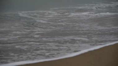 Bulutlu havada İspanyol dalgalı denizi. Kamera geniş sularda döner ve zarif bir ihtişamıyla gelen ritmik dalgaları gösterir. Bulutlu gökyüzü atmosferik bir dokunuş ekliyor.