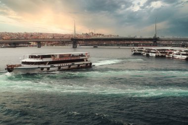 Günbatımında İstanbul, Türkiye. Turist teknesi ilkbaharda Golden Horn 'da denize açılacak. İstanbul 'un eski camili güzel güneşli manzarası. İstanbul ve Türkiye 'de seyahat, turizm ve tatil kavramı