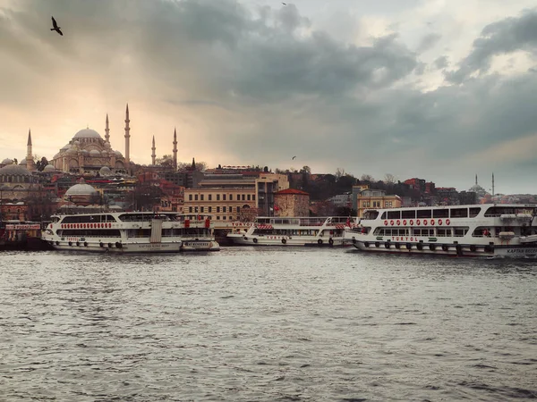 Günbatımında İstanbul, Türkiye. Turist teknesi ilkbaharda Golden Horn 'da denize açılacak. İstanbul 'un eski camili güzel güneşli manzarası. İstanbul ve Türkiye 'de seyahat, turizm ve tatil kavramı