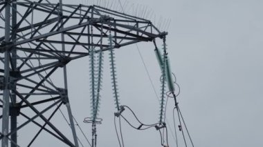 Günbatımı gökyüzünün arka planına karşı kırılmış ve düşmüş yüksek voltajlı bir kule. Rus ordusunun Ukrayna 'nın enerji sistemine saldırması. Rus-Ukrayna savaşı 2022-2023. Kesinti. Yüksek kalite 4k