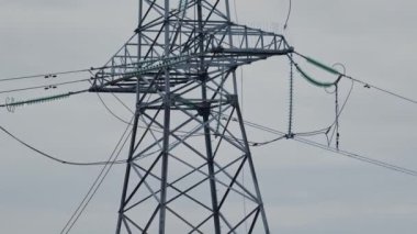 Günbatımı gökyüzünün arka planına karşı kırılmış ve düşmüş yüksek voltajlı bir kule. Rus ordusunun Ukrayna 'nın enerji sistemine saldırması. Rus-Ukrayna savaşı 2022-2023. Kesinti. Yüksek kalite 4k